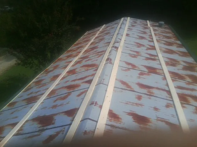 Rusted metal roof panels with new wood purlins before replacement — Storm Damage Roof Repair in Wilsons by Roofing Brothers