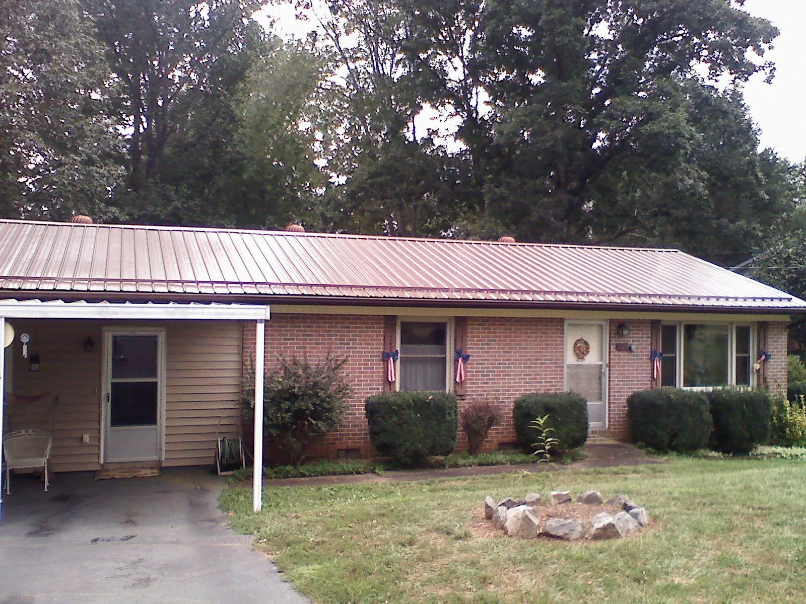 Bronze metal roof and carport on a brick ranch home — Roof Repair work by our crew in Wilsons